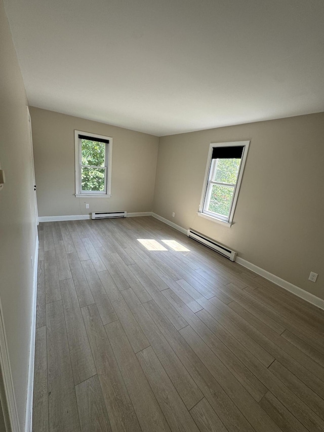25 Minott St Unit 9, South Portland, ME 04106 - empty room featuring a baseboard heating unit, healthy amount of natural light, and wood finished floors