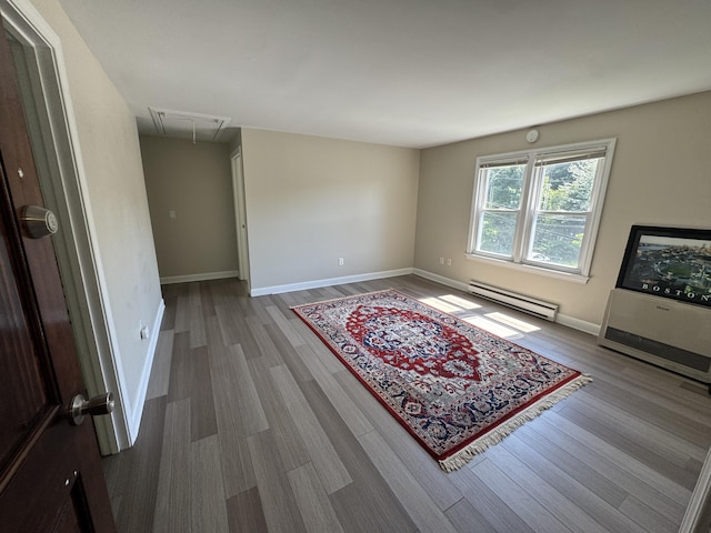 25 Minott St Unit 9, South Portland, ME 04106 - unfurnished room with baseboard heating, attic access, and wood finished floors
