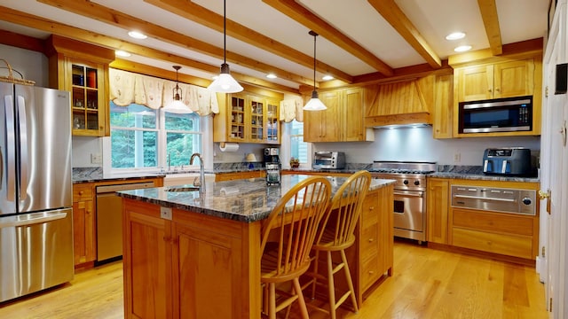 486 Webbs Mills Rd, Raymond, ME 04071 - kitchen with stainless steel appliances, a warming drawer, custom range hood, a center island with sink, and beamed ceiling