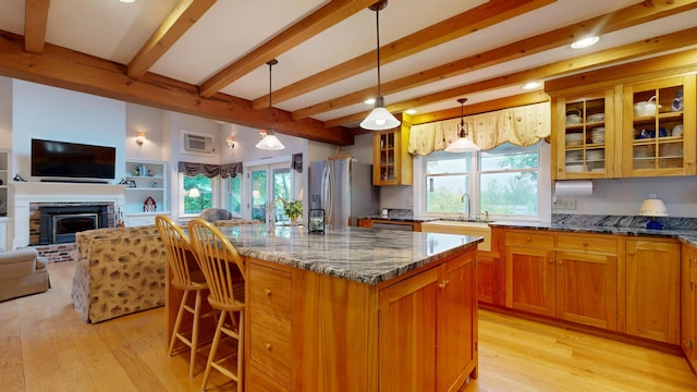 486 Webbs Mills Rd, Raymond, ME 04071 - kitchen with stainless steel fridge, beam ceiling, open floor plan, light wood-style flooring, and dark stone countertops