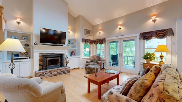 486 Webbs Mills Rd, Raymond, ME 04071 - living room featuring high vaulted ceiling, light wood-style floors, a baseboard radiator, a fireplace, and built in features