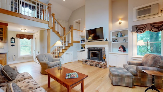 486 Webbs Mills Rd, Raymond, ME 04071 - living room featuring wood finished floors, high vaulted ceiling, stairs, and a brick fireplace