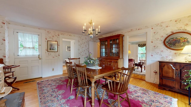 486 Webbs Mills Rd, Raymond, ME 04071 - dining room featuring wallpapered walls, light wood-style floors, a chandelier, crown molding, and wainscoting