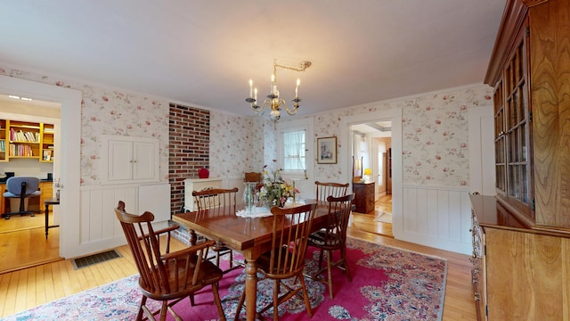 486 Webbs Mills Rd, Raymond, ME 04071 - dining space with wallpapered walls, light wood-style floors, wainscoting, a chandelier, and a desk