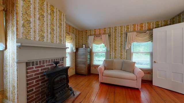 486 Webbs Mills Rd, Raymond, ME 04071 - sitting room featuring a wood stove, wallpapered walls, and hardwood / wood-style flooring