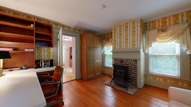 486 Webbs Mills Rd, Raymond, ME 04071 - home office with wallpapered walls, light wood-type flooring, and a wood stove