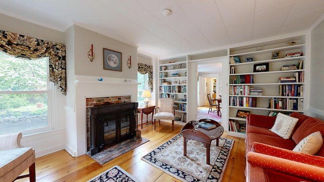 486 Webbs Mills Rd, Raymond, ME 04071 - living area with hardwood / wood-style flooring, a glass covered fireplace, and built in features