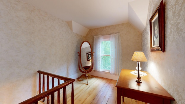 486 Webbs Mills Rd, Raymond, ME 04071 - stairs featuring hardwood / wood-style floors, vaulted ceiling, and wallpapered walls
