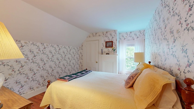 486 Webbs Mills Rd, Raymond, ME 04071 - bedroom with wallpapered walls, wood finished floors, and lofted ceiling