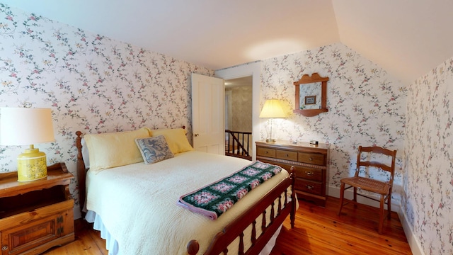 486 Webbs Mills Rd, Raymond, ME 04071 - bedroom with light wood-style flooring, wallpapered walls, and vaulted ceiling