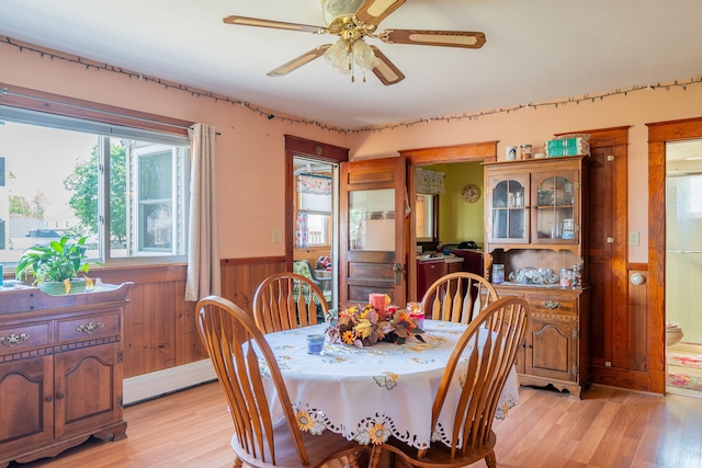 11 Gertrude Ave, Biddeford, ME 04005 - dining area featuring a wainscoted wall, a baseboard radiator, light wood-style floors, ceiling fan, and wood walls