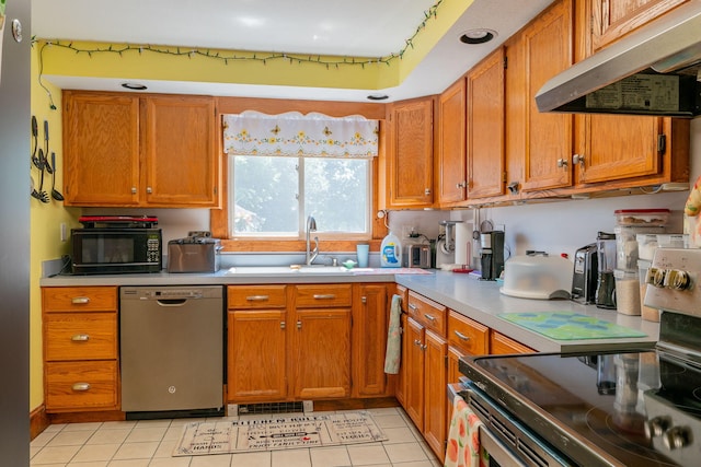 11 Gertrude Ave, Biddeford, ME 04005 - kitchen featuring appliances with stainless steel finishes, under cabinet range hood, light countertops, and brown cabinets