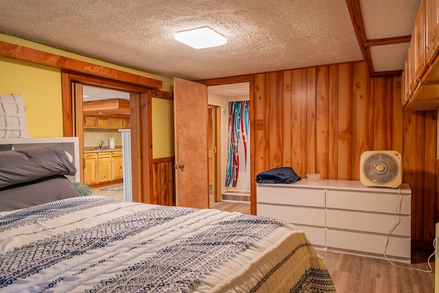 11 Gertrude Ave, Biddeford, ME 04005 - bedroom with wooden walls, light wood-style flooring, and a textured ceiling