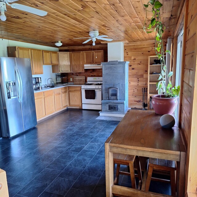 71 Mountain View Dr, Hartford, ME 04220 - kitchen with stainless steel fridge, white range with gas stovetop, a ceiling fan, under cabinet range hood, and light brown cabinets
