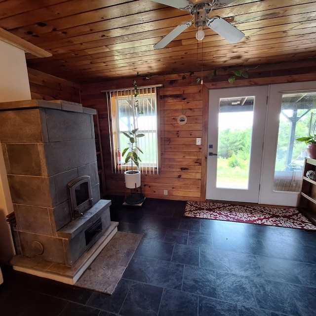 71 Mountain View Dr, Hartford, ME 04220 - living room featuring wood ceiling, healthy amount of natural light, wood walls, a ceiling fan, and dark stone finish floors