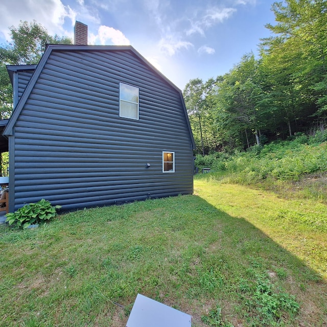 71 Mountain View Dr, Hartford, ME 04220 - view of property exterior with a gambrel roof, a chimney, a yard, and log veneer siding