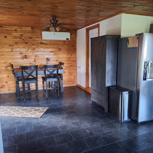 71 Mountain View Dr, Hartford, ME 04220 - dining space with a wall mounted AC, a ceiling fan, wood ceiling, dark stone finish floors, and wooden walls