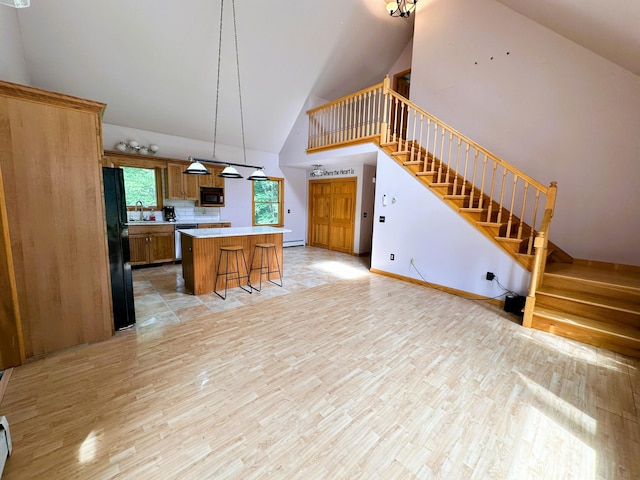 27 Hodgdon Rd, Levant, ME 04456 - kitchen with high vaulted ceiling, light wood-type flooring, a kitchen breakfast bar, light countertops, and a center island