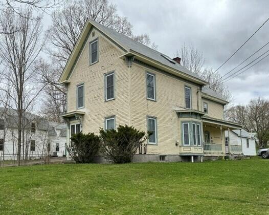 46 Cedar St, Dover-Foxcroft, ME 04426 - rear view of property featuring a lawn and a chimney