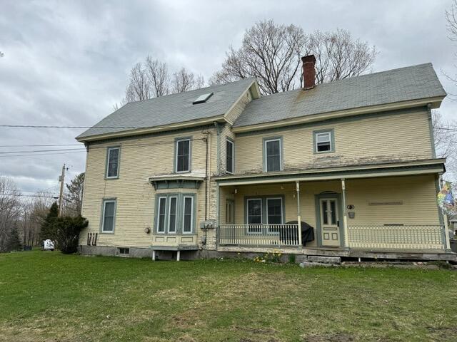 46 Cedar St, Dover-Foxcroft, ME 04426 - back of property featuring a porch, a chimney, and a yard