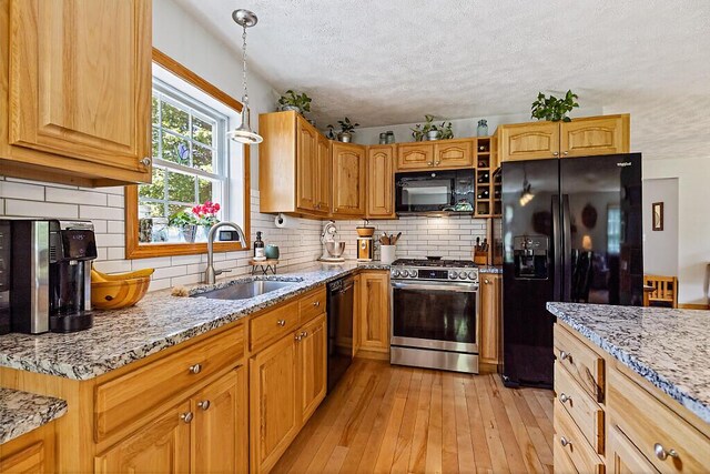 34 Cari Way, Sidney, ME 04330 - kitchen featuring black appliances, a textured ceiling, light stone countertops, light wood-type flooring, and pendant lighting