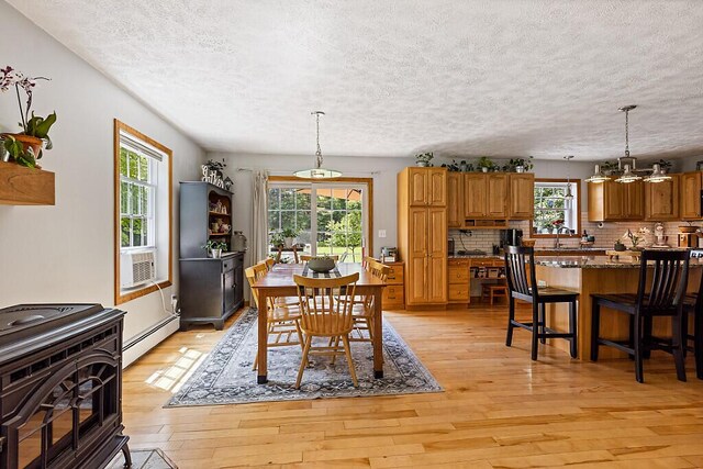 34 Cari Way, Sidney, ME 04330 - dining area with a baseboard heating unit, plenty of natural light, a textured ceiling, light wood-style floors, and cooling unit