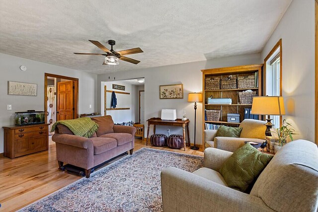 34 Cari Way, Sidney, ME 04330 - living room featuring light wood-type flooring, a textured ceiling, and ceiling fan