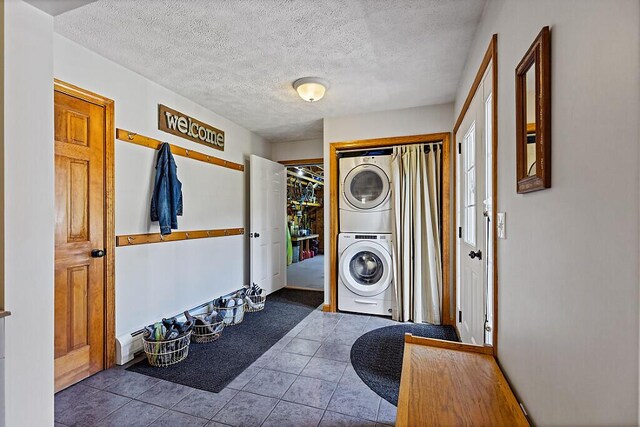 34 Cari Way, Sidney, ME 04330 - laundry room with stacked washer and clothes dryer, a textured ceiling, and tile patterned flooring