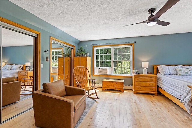 34 Cari Way, Sidney, ME 04330 - bedroom featuring a baseboard radiator, a textured ceiling, light wood finished floors, and cooling unit