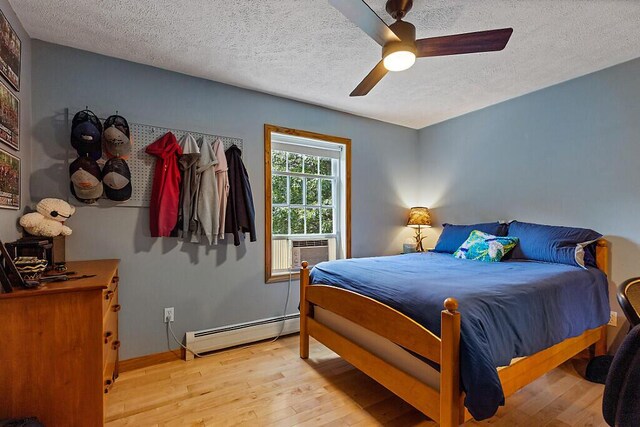 34 Cari Way, Sidney, ME 04330 - bedroom featuring baseboard heating, wood finished floors, a textured ceiling, and a ceiling fan