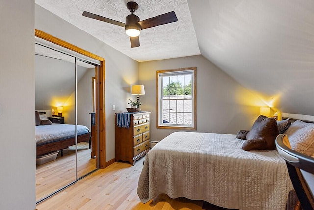 34 Cari Way, Sidney, ME 04330 - bedroom with light wood finished floors, a closet, lofted ceiling, a textured ceiling, and ceiling fan