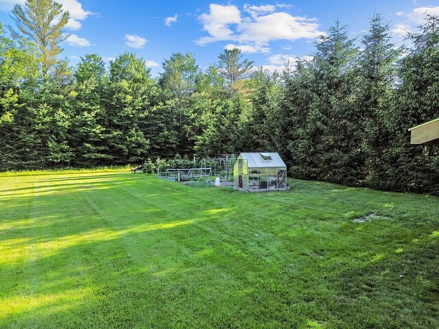 34 Cari Way, Sidney, ME 04330 - view of grassy yard featuring an exterior structure, an outbuilding, a garden, and a forest view