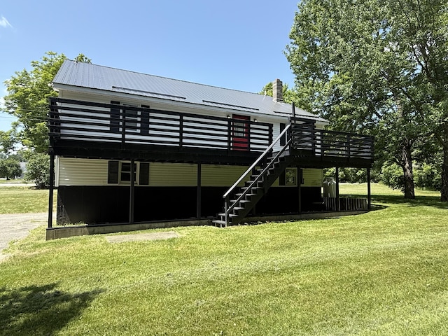 199 Middle Rd, Bradford, ME 04410 - back of property featuring a deck, a lawn, stairs, and a metal roof