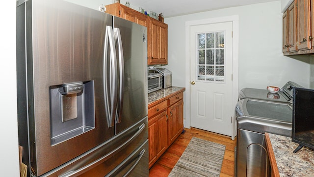 133 Hio Ridge Rd, Bridgton, ME 04009 - kitchen featuring stainless steel fridge, wood finished floors, brown cabinetry, and washer and dryer
