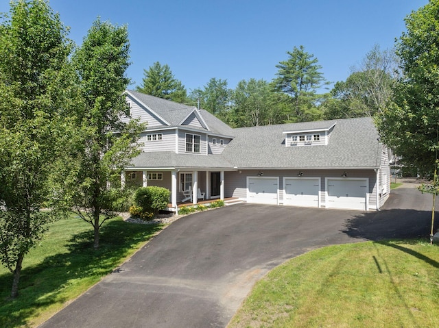 65 Wildbrook Ln, Eliot, ME 03903 - view of front of property with driveway, a front lawn, an attached garage, covered porch, and a shingled roof