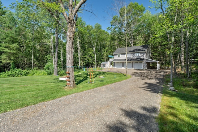 65 Wildbrook Ln, Eliot, ME 03903 - view of front of home with dirt driveway, a garage, a front lawn, and a wooded view