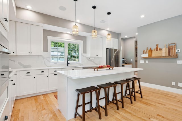 65 Wildbrook Ln, Eliot, ME 03903 - kitchen with light wood-style flooring, backsplash, freestanding refrigerator, white cabinets, and recessed lighting