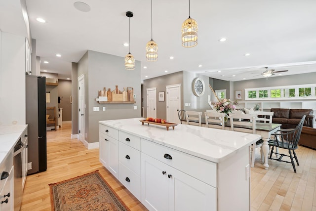 65 Wildbrook Ln, Eliot, ME 03903 - kitchen with light wood-type flooring, a center island, white cabinetry, light stone countertops, and recessed lighting
