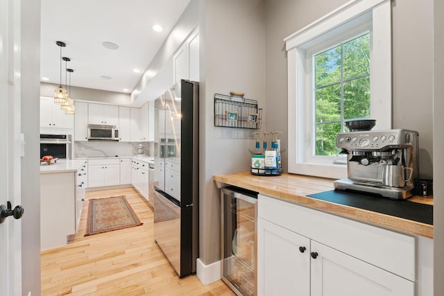 65 Wildbrook Ln, Eliot, ME 03903 - kitchen featuring appliances with stainless steel finishes, wine cooler, light wood-style flooring, healthy amount of natural light, and recessed lighting