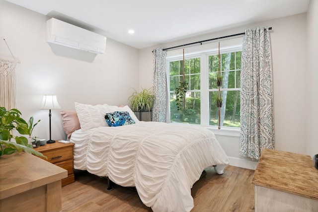 65 Wildbrook Ln, Eliot, ME 03903 - bedroom featuring a wall mounted air conditioner, light wood-style flooring, multiple windows, and recessed lighting