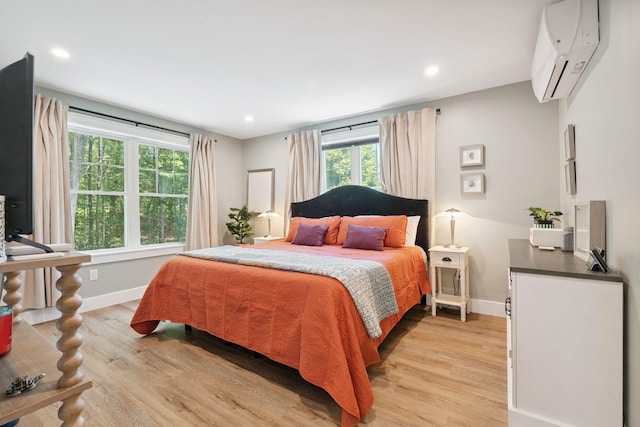 65 Wildbrook Ln, Eliot, ME 03903 - bedroom with an AC wall unit, multiple windows, light wood-style floors, and recessed lighting