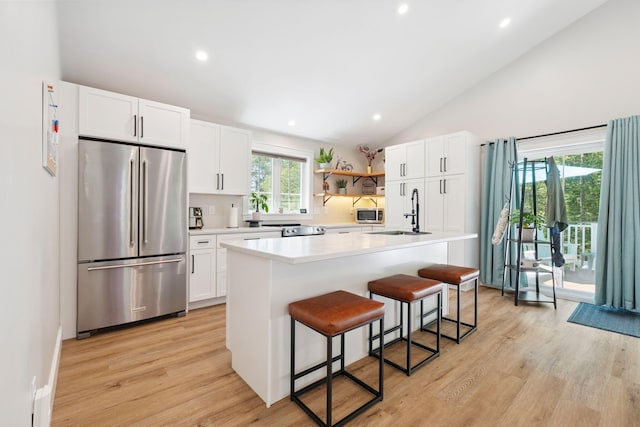 65 Wildbrook Ln, Eliot, ME 03903 - kitchen featuring appliances with stainless steel finishes, light wood-type flooring, a kitchen breakfast bar, white cabinets, and light countertops