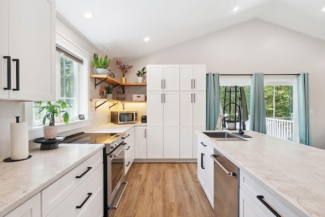 65 Wildbrook Ln, Eliot, ME 03903 - kitchen featuring appliances with stainless steel finishes, lofted ceiling, light countertops, light wood-type flooring, and white cabinets