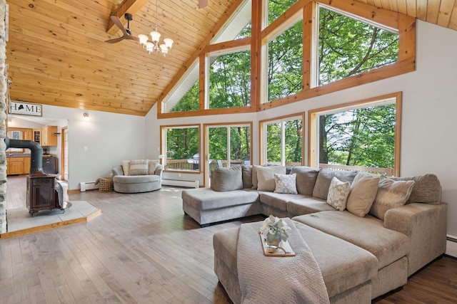 2288 W River Rd, Sidney, ME 04330 - living room with high vaulted ceiling, a wood stove, a baseboard radiator, a wood ceiling with exposed beams, and hardwood / wood-style floors