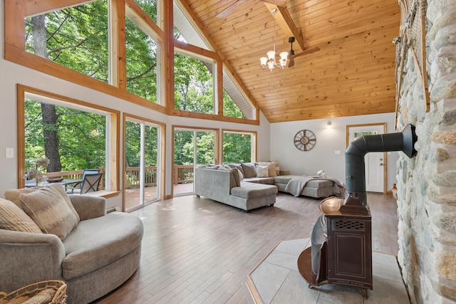 2288 W River Rd, Sidney, ME 04330 - living room with high vaulted ceiling, a wood ceiling with exposed beams, a wood stove, hardwood / wood-style flooring, and a chandelier