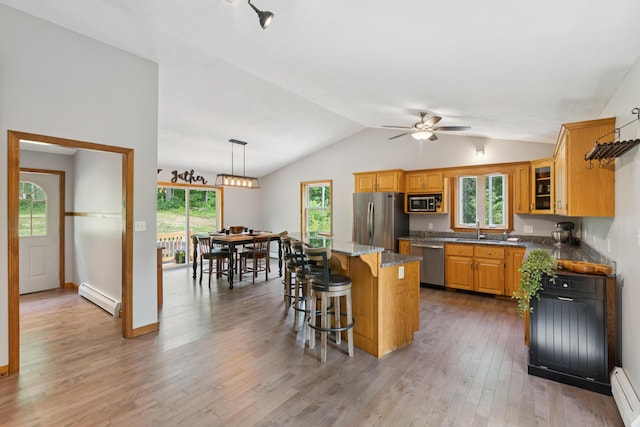 2288 W River Rd, Sidney, ME 04330 - kitchen featuring stainless steel appliances, baseboard heating, a ceiling fan, a kitchen island, and light wood-style flooring