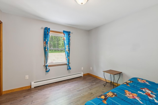 2288 W River Rd, Sidney, ME 04330 - unfurnished bedroom featuring a baseboard heating unit and wood finished floors