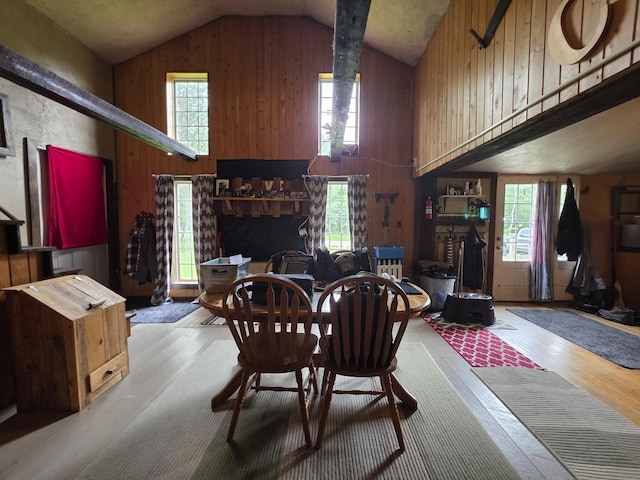 17 Cross St, Kingman Twp, ME 04451 - dining room featuring vaulted ceiling, wood finished floors, wooden walls, and a wood stove