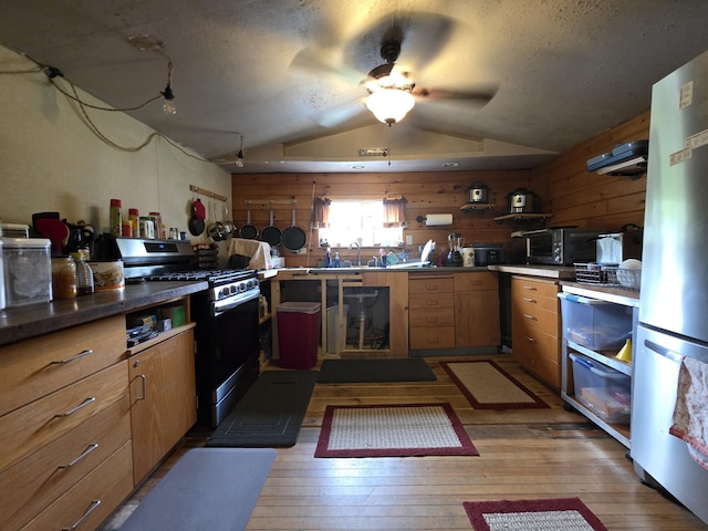 17 Cross St, Kingman Twp, ME 04451 - kitchen with stainless steel gas stove, freestanding refrigerator, lofted ceiling, light wood-type flooring, and open shelves