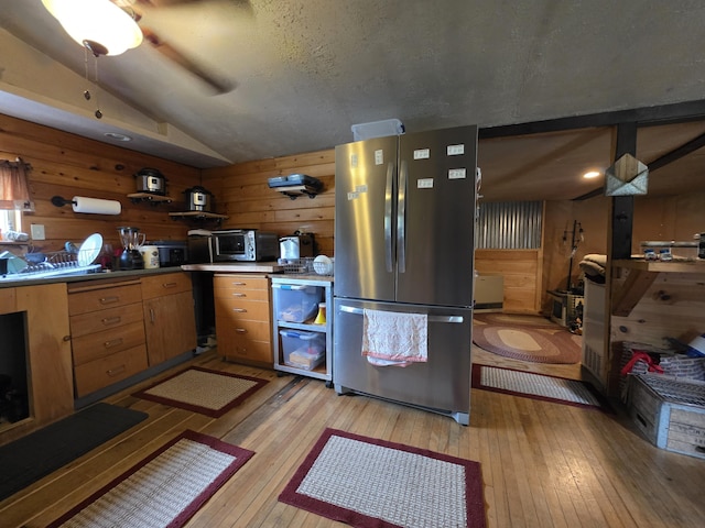 17 Cross St, Kingman Twp, ME 04451 - kitchen featuring freestanding refrigerator, vaulted ceiling, light wood-type flooring, wooden walls, and a ceiling fan